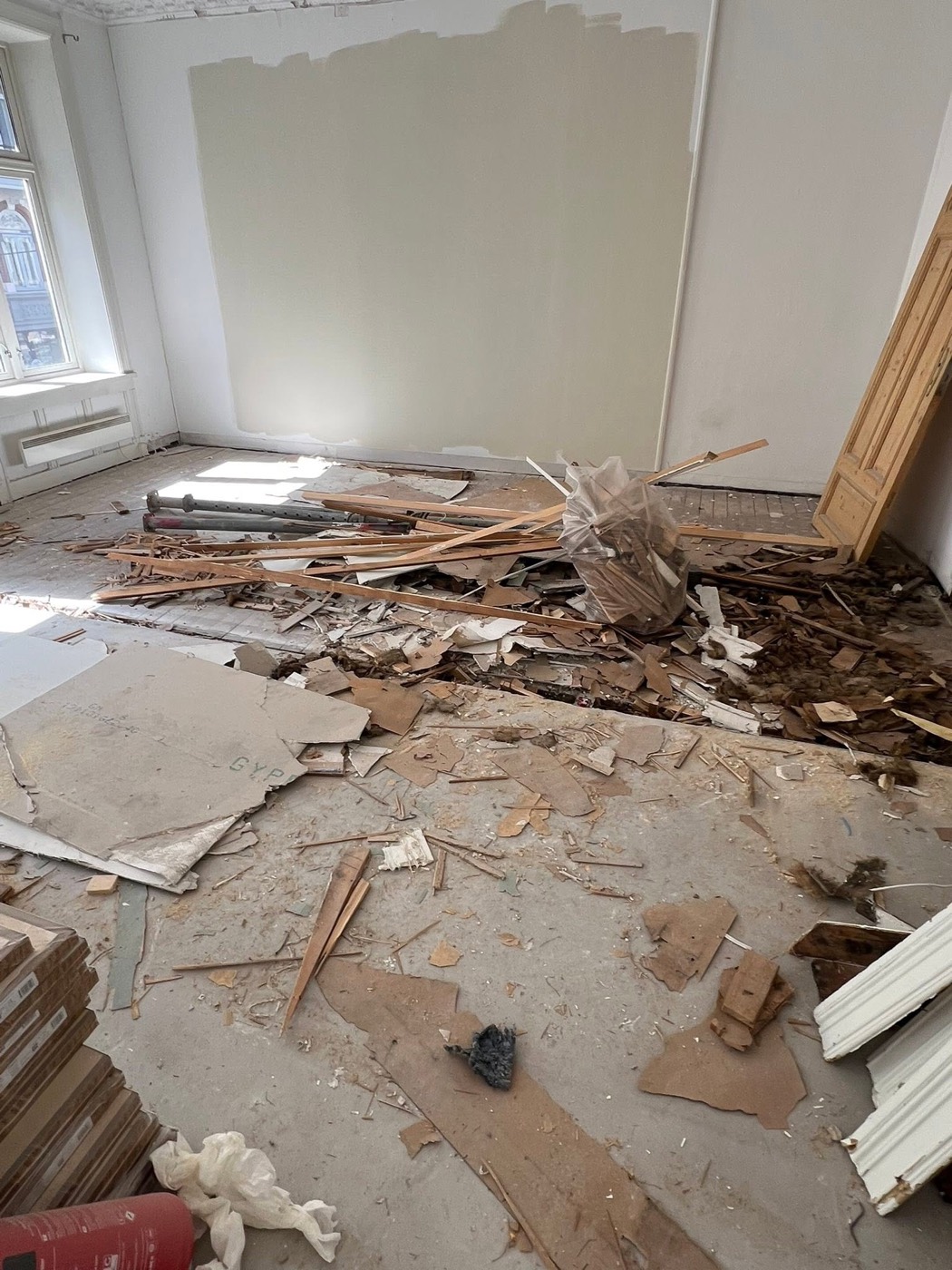 Rom med rivningsmateriale og støv før rydding